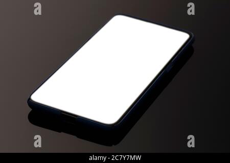 Mockup smartphone con schermo bianco sullo sfondo del tavolo. Foto Stock