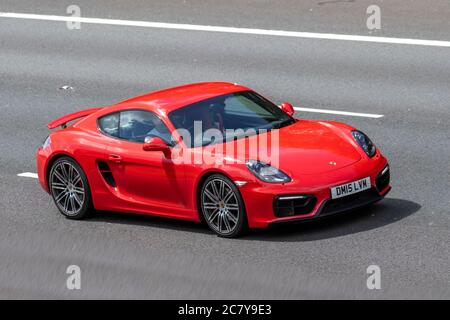 2015 Red Porsche Cayman GTS S-A con spoiler in alto; veicoli in movimento per il traffico veicolare, auto che guidano veicoli su strade del Regno Unito, motori, automobili sulla rete autostradale M6. Foto Stock