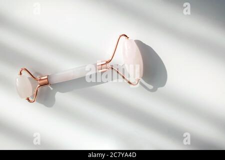 Rullo di massaggio della giada del viso o gua sha su sfondo bianco. Foto Stock
