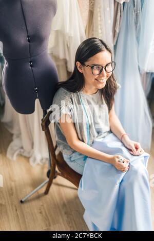 Una mano di un giovane marinaio cucire un tessuto bianco sartoria secondo la tradizione dei sarti. Il dressaker utilizza perfettamente ago e filo a. Foto Stock