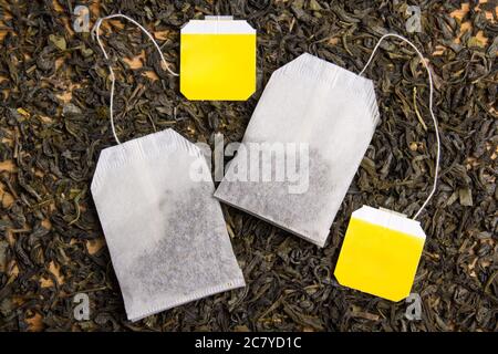 sfondo con tè nero essiccato e due bustine di tè Foto Stock