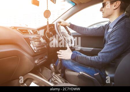 Uomo quadriplegico seduto sul sedile della sua auto di controllo personalizzata. Sta sorridendo per la fotocamera. Foto Stock