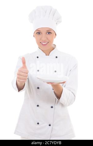 giovane chef donna in uniforme che tiene piatto vuoto e pollici su isolato su sfondo bianco Foto Stock