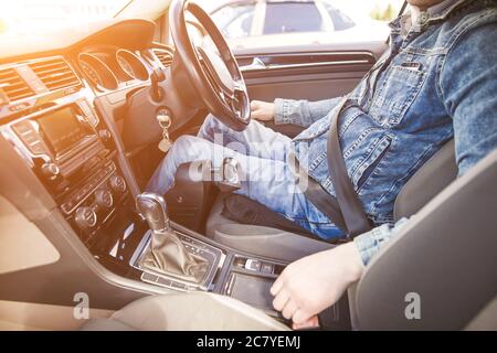 Uomo quadriplegico seduto sul sedile della sua auto di controllo personalizzata. Sta sorridendo per la fotocamera. Foto Stock