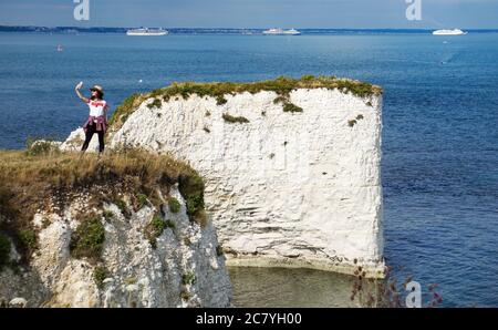 Studland, Regno Unito. 19 luglio 2020. Una giovane donna prende un selfie a Old Harry Rocks vicino Studland sull'isola di Purbeck in Dorset. Le formazioni di gesso segnano il punto più orientale della Jurassic Coast, un sito patrimonio dell'umanità dell'UNESCO. Attualmente offrono una vista ottimale delle navi da crociera ancorate a Poole Bay al largo di Bournemouth. Credit: Richard Crease/Alamy Live News Foto Stock