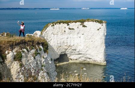 Studland, Regno Unito. 19 luglio 2020. Una giovane donna prende un selfie a Old Harry Rocks vicino Studland sull'isola di Purbeck in Dorset. Le formazioni di gesso segnano il punto più orientale della Jurassic Coast, un sito patrimonio dell'umanità dell'UNESCO. Attualmente offrono una vista ottimale delle navi da crociera ancorate a Poole Bay al largo di Bournemouth. Credit: Richard Crease/Alamy Live News Foto Stock