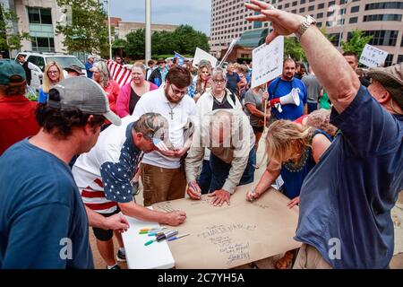 Indianapolis, Stati Uniti. 19 luglio 2020. I manifestanti firmano un banner da lasciare alle porte dello Statehouse durante il We Will Not Aconda anti maschera rally.People protesta contro sia il sindaco di Indianapolis Joe Hogsett's maschera ordine e l'estensione del governatore dell'Indiana Eric Holcomb della chiusura dello stato. Il Dipartimento della Salute degli Stati Uniti ha registrato un totale di 3,898,550 infezioni, 143,289 decessi e 1,802,338 rinvenuti dall'inizio dell'epidemia di Coronavirus (Covid-19). Credit: SOPA Images Limited/Alamy Live News Foto Stock