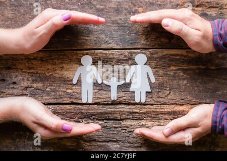 Mani maschili e femminili, silhouette di un concetto di famiglia di carta cura Foto Stock