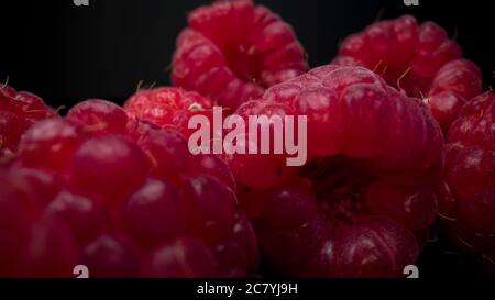 Vista macro dei lamponi. Primo piano di lampone fresco, deciso e gustoso. Spuntini estivi vegani organici crudi, frutti di bosco. Foto Stock