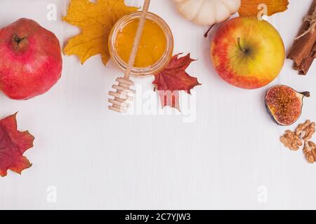 Frutta d'autunno e foglie di acero secco su tavola bianca Foto Stock