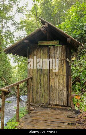 Spogliatoio costruito di tronchi di bambù da un fiume in una foresta tropicale pioggia. Piccola casa a Spray Waterfall su Bali Island alta in montagna. Valle Foto Stock