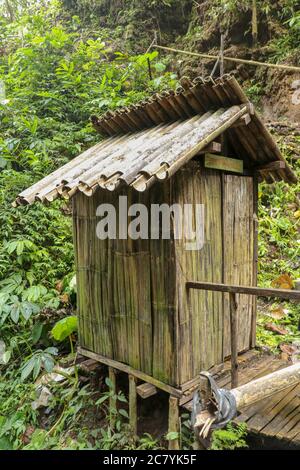 Spogliatoio costruito di tronchi di bambù da un fiume in una foresta tropicale pioggia. Piccola casa a Spray Waterfall su Bali Island alta in montagna. Valle Foto Stock