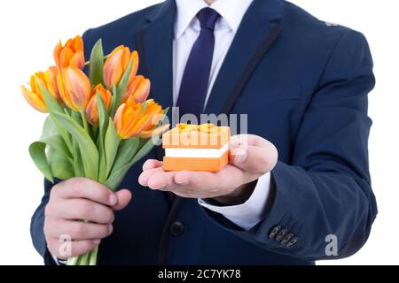 confezione regalo con anello di nozze e fiori in mani maschili isolati su sfondo bianco Foto Stock