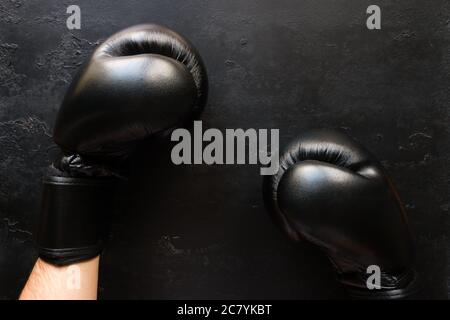 uomo in guanti da boxe su sfondo nero Foto Stock