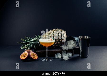 Cocktail di ananas e frutto della passione con polpa in un bicchiere su fondo nero. Messa a fuoco selettiva. Foto Stock