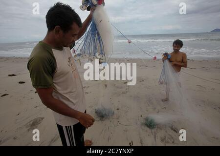 Pescatori che preparano reti da pesca sulla spiaggia di Kalala a Wula, Wula Waijelu, Sumba orientale, Nusa Tenggara orientale, Indonesia. Foto Stock