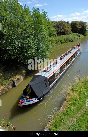 Una barca stretta che sta per passare sotto il ponte sul canale Kennett & Avon, Wiltshire, Inghilterra Foto Stock