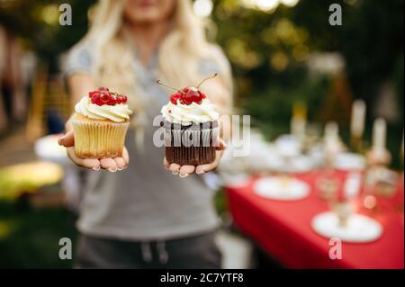 Tavolo, tè partito, donna mostra torte fresche Foto Stock