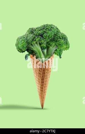 Broccoli grezzi in cono di wafer su sfondo verde chiaro. Alimentazione sana, cibo e verdure di stagione raccolto. Primo piano, spazio per la copia Foto Stock