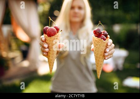 Tavolo, donna mostra corna con frutti di bosco Foto Stock