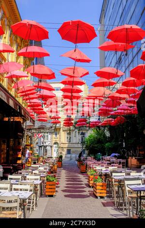 Belgrado / Serbia - 16 maggio 2020: Ombrelli rossi sopra il ristorante all'aperto in via King Peter nella parte bohémien vecchia della capitale serba Belgrado Foto Stock