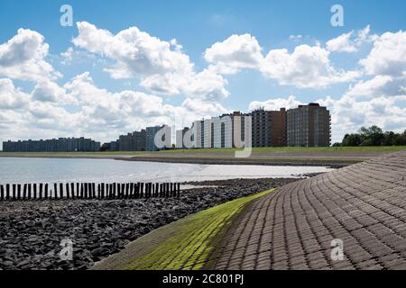 Terneuzen, Paesi Bassi, 12 luglio 2020, edifici di appartamenti e una diga con pali sulla costa Foto Stock