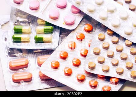Compresse e capsule di diversi colori confezionate in blister. Informazioni farmaceutiche o mediche Foto Stock
