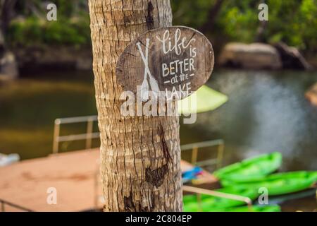 Tavola di legno con una frase motivazionale. La vita migliore al lago. Citazione dell'ispirazione Foto Stock