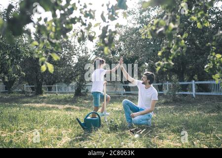 Ragazzo dai capelli scuri e suo padre che fa cinque e che si sente meraviglioso Foto Stock