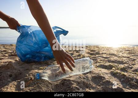 Volontariato raccogliere bottiglie di plastica sprecata pulizia della spiaggia Outdoor Foto Stock