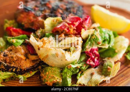 Hamburger a basso contenuto di carb (bunless) servito su una tavola rustica di legno con insalata, fuoco selettivo Foto Stock