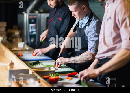 Maschio di cuochi prepara sushi al ristorante cucina Foto Stock