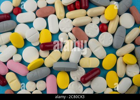 Pillole di medicina farmaceutica assortite isolate con backgorund blu. Foto concettuale sul tema Coronavirus e Covid-19. Foto Stock