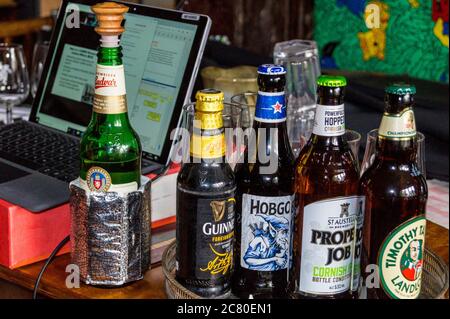 FOTO bottiglie di birra su un tavolo da pranzo selezionato per un evento online di degustazione di birra CAMRA durante la pandemia di Covid-19 Foto Stock