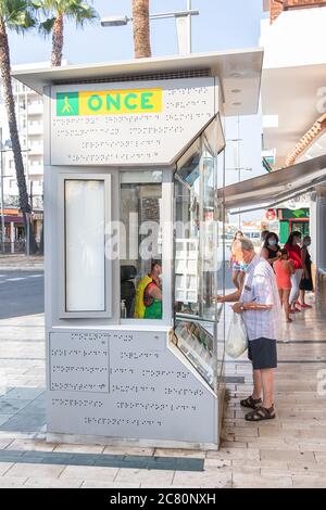Punta Umbria, Huelva, Spagna - 11 luglio 2020: L'uomo in maschera protettiva sta acquistando biglietti per lotteria in un chiosco A Punta Umbria, Andalusia, Spagna Foto Stock
