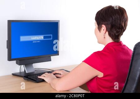 donna d'affari che scarica qualcosa da internet usando il pc in ufficio Foto Stock