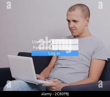 internet concept - giovane bell'uomo seduto sul divano con il computer e registrazione account in social network Foto Stock