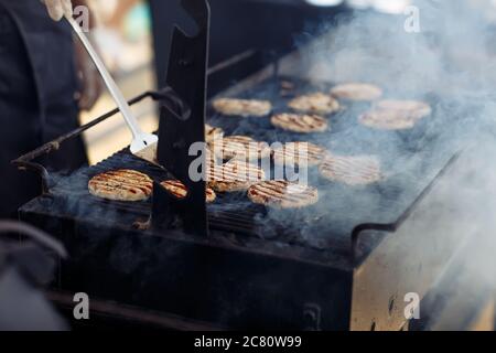 Il processo di grigliatura per preparare i tagli di carne per gli hamburger durante le feste di nozze Foto Stock