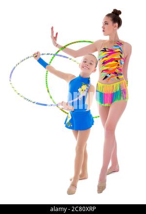 giovane donna e bambina che fanno ginnastica con cerchi isolati su sfondo bianco Foto Stock