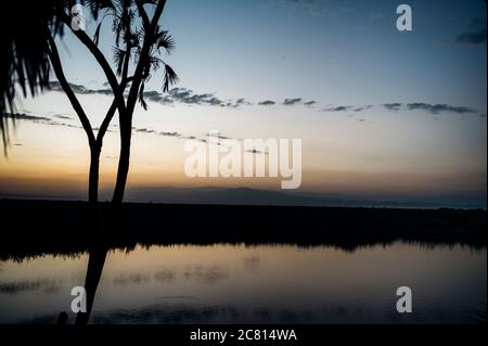 Tramonto sulla naturale oasi termale calda al Doho Safari Lodge nella regione Afar dell'Etiopia. Foto Stock