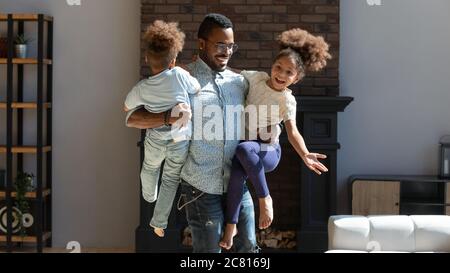 Felice padre biraciale divertirsi giocando con i bambini Foto Stock