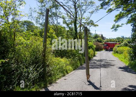 Asta del telefono rotta o asta del telegrafo appesa alla strada Foto Stock