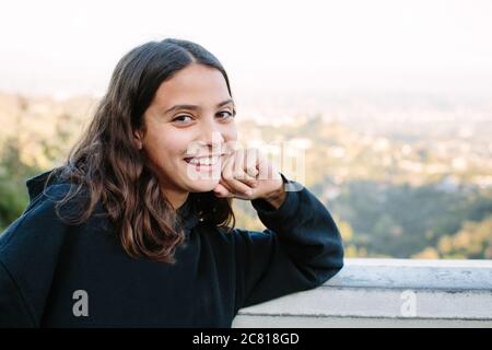 La ragazza di dodici anni sorride per un ritratto cheesy a. una vista panoramica Foto Stock