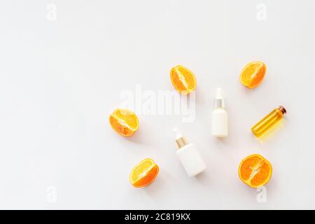 Olio essenziale arancione e sieri cosmetici isolati su sfondo bianco, vista dall'alto, piatto. Concetto di cosmetica naturale Foto Stock