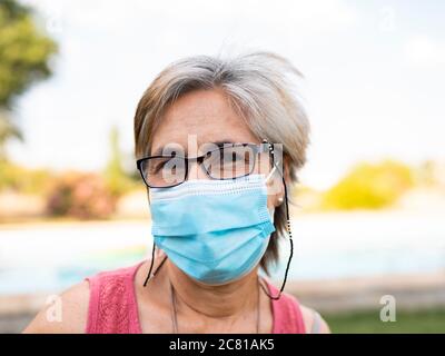bella donna anziana con capelli bianchi con maschera da covid-19 Foto Stock