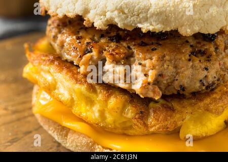 Colazione fatta in casa, sandwich con salsiccia e patate con uova e formaggio Foto Stock