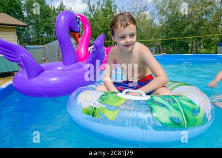 ragazzo in cortile sopra la piscina Foto Stock