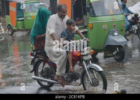 Lahore, Pakistan. 20 luglio 2020. I pendolari pakistani si muovono attraverso una strada allagata dopo il pesante incantesimo pioggia monsone nella capitale provinciale di Lahore. (Foto di Rana Sajid Hussain/Pacific Press) Credit: Pacific Press Agency/Alamy Live News Foto Stock