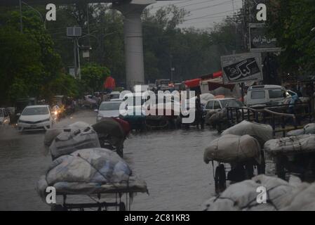 Lahore, Pakistan. 20 luglio 2020. I pendolari pakistani si muovono attraverso una strada allagata dopo il pesante incantesimo pioggia monsone nella capitale provinciale di Lahore. (Foto di Rana Sajid Hussain/Pacific Press) Credit: Pacific Press Agency/Alamy Live News Foto Stock