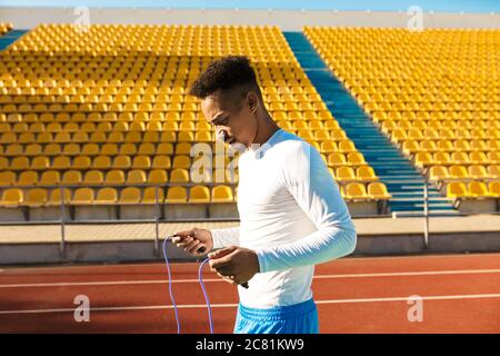 Giovane sportivo afroamericano con corda saltellante in allenamento allo stadio Foto Stock